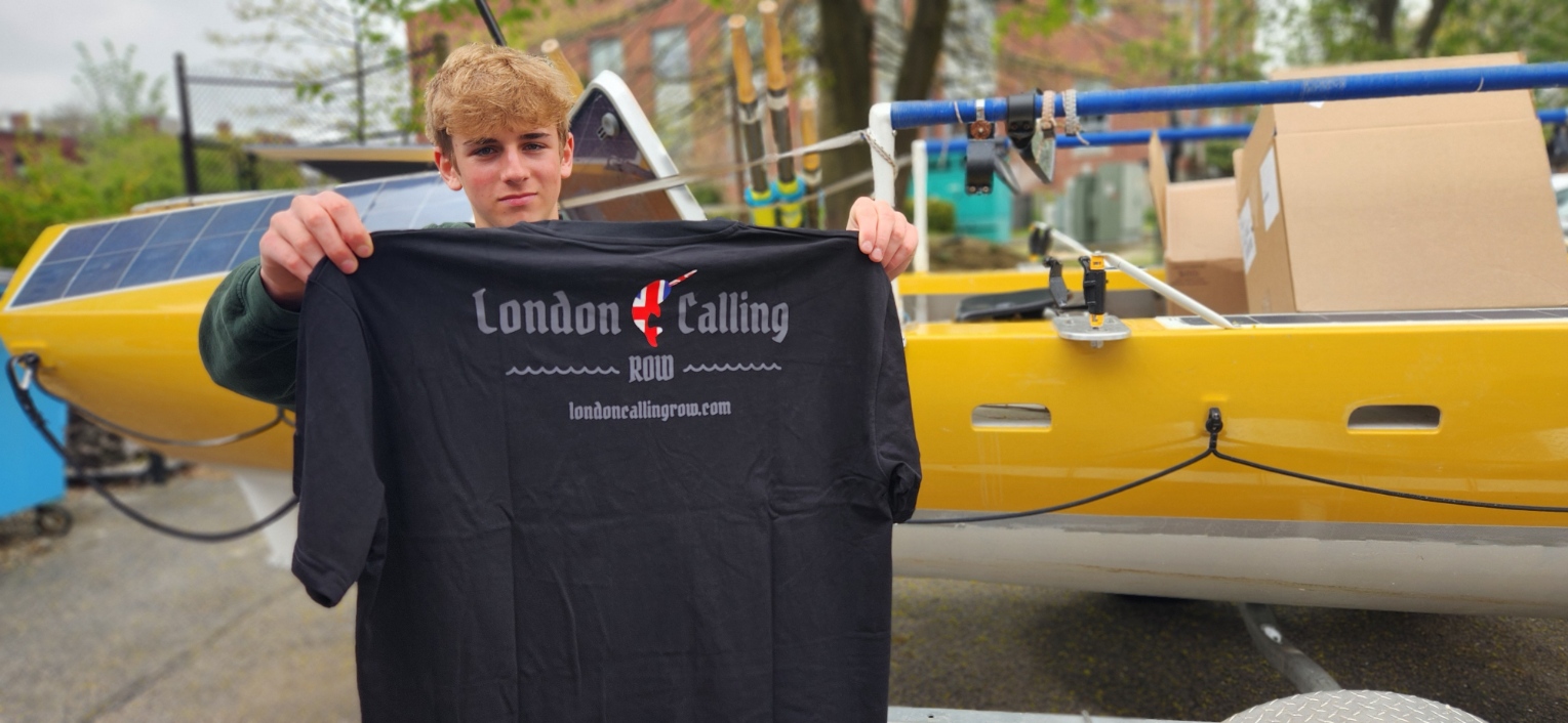 A London Calling Row T-shirt held beside the yellow rowing boat
